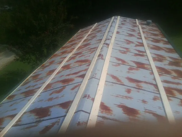Rusted metal roof panels with new wood purlins before replacement — Storm Damage Roof Repair in Vida by Roofing Brothers
