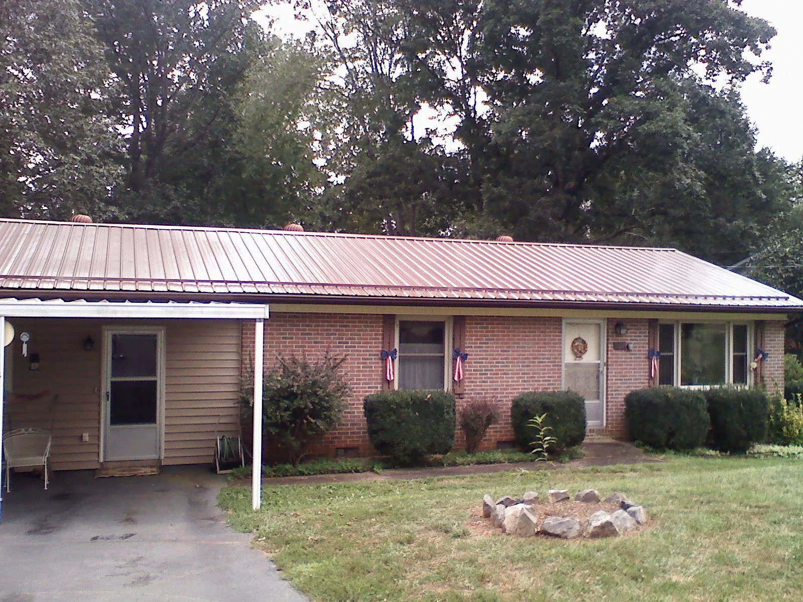 Bronze metal roof and carport on a brick ranch home — Roof Repair work by our crew in Vida
