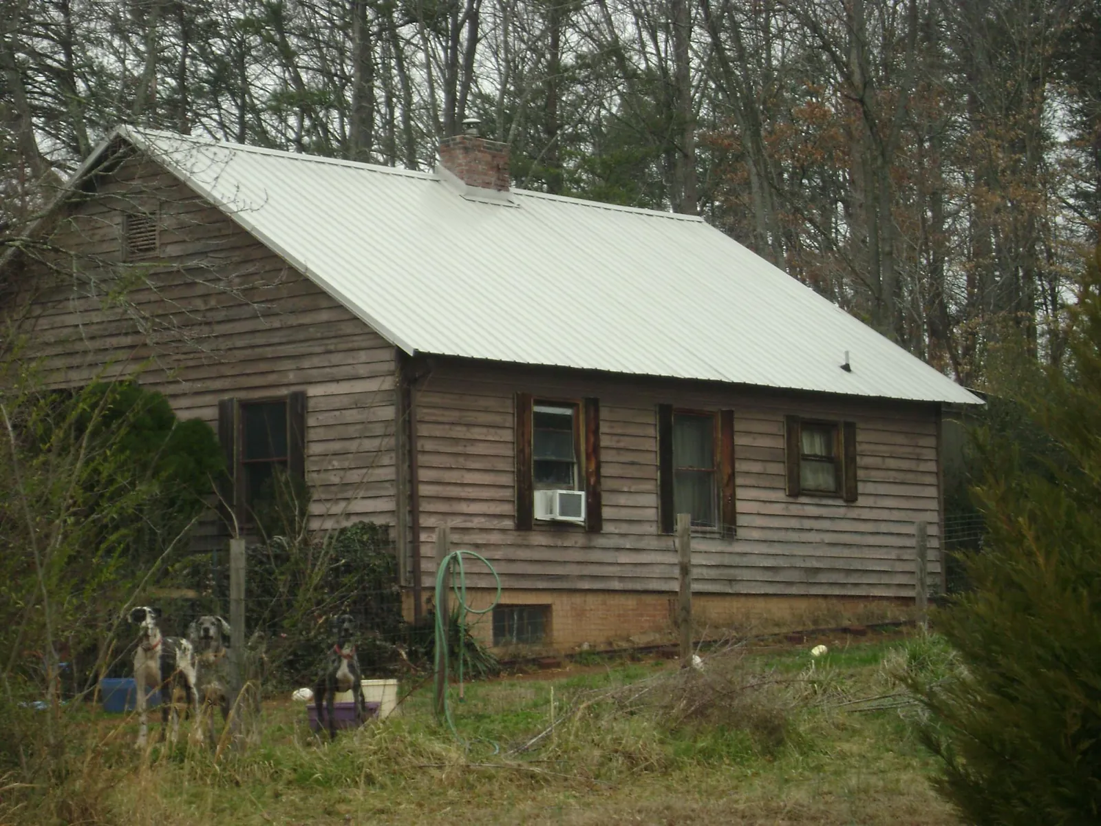 White metal roof on an old wood sided farmhouse, from a Metal Roof Installation job in Vida